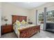 Main bedroom with wood bed frame, yellow bedding, and window view at 5423 Kenmore Ln, Orlando, FL 32839