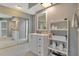Clean bathroom with white vanity, large mirror, and a shelving unit at 545 Brown Pelican Dr, Daytona Beach, FL 32119