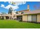 Back of house with grassy yard and screened porch at 545 Brown Pelican Dr, Daytona Beach, FL 32119