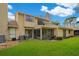 Back of house with grassy yard, screened porch and AC unit at 545 Brown Pelican Dr, Daytona Beach, FL 32119