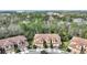 Aerial view of three-story townhouses with tile roofs in a wooded community at 8145 Roseville Blvd, Davenport, FL 33896