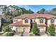 Three-story townhouse with tile roof, two-car garage, and landscaping at 8145 Roseville Blvd, Davenport, FL 33896