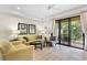 Living room with yellow couch, patio access, and tiled floors at 8145 Roseville Blvd, Davenport, FL 33896