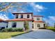 Two-story house with a tile roof, white exterior, and a two-car garage at 133 Summer Place Loop, Clermont, FL 34714