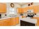 Kitchen with light wood cabinets, double sink, and an island at 133 Summer Place Loop, Clermont, FL 34714