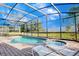 Resort-style pool and spa with screened enclosure and lounge chairs at 133 Summer Place Loop, Clermont, FL 34714