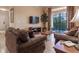 Living room with brown sofas, wood floors, and access to a balcony at 1351 Tuscan Ter # 8401, Davenport, FL 33896