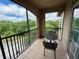 Spacious screened balcony with table and chairs, offering a wooded view at 1351 Tuscan Ter # 8401, Davenport, FL 33896