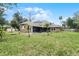 House's back view, showing a large backyard with lush green grass at 1437 Pecos Dr, Ormond Beach, FL 32174