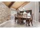 Elegant dining room with wood table and chairs, and stone accent wall at 1437 Pecos Dr, Ormond Beach, FL 32174