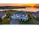 Two-story house with lake view at sunset. Landscaped yard and driveway at 16750 Sanctuary Dr, Winter Garden, FL 34787