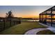 Landscaped backyard with lake view,fence, and brick walkway at sunset at 16750 Sanctuary Dr, Winter Garden, FL 34787