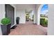 Inviting front porch with brick pavers,potted plants, and a comfortable seating area at 16750 Sanctuary Dr, Winter Garden, FL 34787
