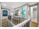 Elegant upstairs hallway with wrought iron railing and light hardwood floors at 16750 Sanctuary Dr, Winter Garden, FL 34787