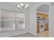 Dining room with large window, chandelier, and view into kitchen at 204 Paloma Dr, Davenport, FL 33837