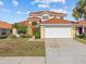 Two-story house with a tan exterior, tile roof, and a two-car garage at 204 Paloma Dr, Davenport, FL 33837