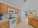 Kitchen with light wood cabinets, stainless steel appliances, and tile floors at 204 Paloma Dr, Davenport, FL 33837