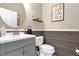 Modern bathroom with gray vanity, wood-paneled walls, and white toilet at 20811 Sullivan Ranch Blvd, Mount Dora, FL 32757