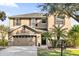 Two-story house with tan siding, brown accents, and a two-car garage at 20811 Sullivan Ranch Blvd, Mount Dora, FL 32757