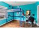 A colorful bedroom featuring a loft bed, desk, and bright turquoise walls at 211 Indiana Ave, St Cloud, FL 34769
