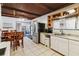 A cozy kitchen with stainless steel refrigerator, white cabinetry, and wooden table with chairs at 211 Indiana Ave, St Cloud, FL 34769