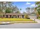 Brick ranch home with a landscaped lawn and attached garage at 223 Royal Oaks Cir, Longwood, FL 32779
