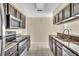 Galley style kitchen with granite counters and dark cabinets at 2321 Prime Cir # B, Kissimmee, FL 34746