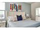 Main bedroom with a king bed, blue and beige pillows, and artwork at 2641 Tranquility Way, Kissimmee, FL 34746