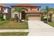 Two-story house with a large driveway and landscaped yard at 2641 Tranquility Way, Kissimmee, FL 34746