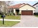 One-story home with brown garage door and brick accents at 273 Ancona Ave, Debary, FL 32713