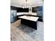 Modern kitchen with island, black cabinets, and wood-look tile floors at 273 Ancona Ave, Debary, FL 32713