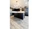 Modern kitchen with island, black cabinets, and wood-look tile floors at 273 Ancona Ave, Debary, FL 32713