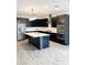 Open concept kitchen with island, black cabinets, and wood-look tile floors at 273 Ancona Ave, Debary, FL 32713
