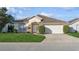 One-story house with a two-car garage and well-maintained lawn at 305 Therese St, Davenport, FL 33897