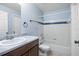 Clean bathroom with a tub, toilet and wood vanity at 4172 Versailles Dr # 4172D, Orlando, FL 32808