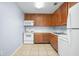 Efficient kitchen featuring wood cabinets, white appliances, and tile flooring at 4172 Versailles Dr # 4172D, Orlando, FL 32808