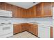 Kitchen with wood cabinets, white appliances, and tile floor at 4172 Versailles Dr # 4172D, Orlando, FL 32808
