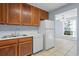 Kitchen boasts wood cabinets, white appliances, and view to dining area at 4172 Versailles Dr # 4172D, Orlando, FL 32808