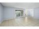 Living room with tile floors and sliding glass doors leading to a balcony at 4172 Versailles Dr # 4172D, Orlando, FL 32808
