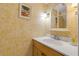 Small bathroom with light wood vanity and yellow textured walls at 815 Ocean Shore Blvd # U9A, Ormond Beach, FL 32176
