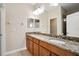 Bathroom featuring a double sink vanity with granite countertop and wood cabinets at 9025 Savannah Julip Ln, Orlando, FL 32832