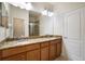 Bathroom featuring a double sink vanity with granite countertop and wood cabinets at 9025 Savannah Julip Ln, Orlando, FL 32832