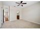 A carpeted bedroom leads to a bathroom and hallway with hardwood flooring at 9025 Savannah Julip Ln, Orlando, FL 32832