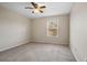 A bright bedroom with a ceiling fan, neutral walls, plush carpeting, and a window at 9025 Savannah Julip Ln, Orlando, FL 32832