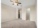 A bright bedroom with a ceiling fan, neutral walls, plush carpeting, and two door openings at 9025 Savannah Julip Ln, Orlando, FL 32832