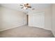 A cozy bedroom featuring neutral walls, plush carpeting, closet and adjacent doorway at 9025 Savannah Julip Ln, Orlando, FL 32832