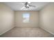 Spacious bedroom with neutral carpet, ceiling fan, and a bright window at 9025 Savannah Julip Ln, Orlando, FL 32832