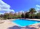 Inviting community pool with plenty of lounge chairs and lush tropical landscaping at 9025 Savannah Julip Ln, Orlando, FL 32832