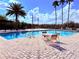 Sparkling community pool with lounge chairs, tables, and pristine blue water at 9025 Savannah Julip Ln, Orlando, FL 32832