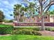 Elegant community sign for Nona Terrace, adorned with lush landscaping and swaying palm trees at 9025 Savannah Julip Ln, Orlando, FL 32832